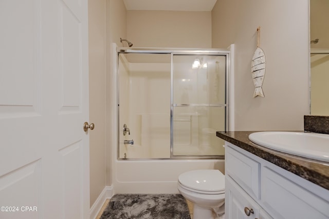 full bathroom with vanity, toilet, and enclosed tub / shower combo