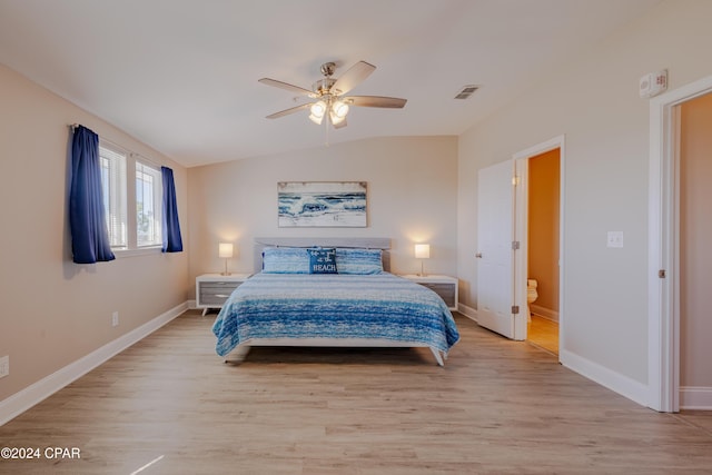 bedroom with ceiling fan, ensuite bathroom, lofted ceiling, and light wood-type flooring