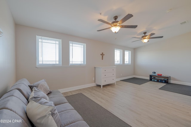 living room with ceiling fan, a healthy amount of sunlight, and light wood-type flooring