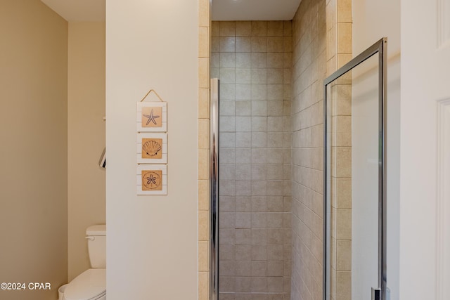 bathroom featuring toilet and a shower with door