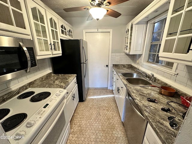 kitchen with sink, a textured ceiling, tasteful backsplash, white cabinetry, and stainless steel appliances