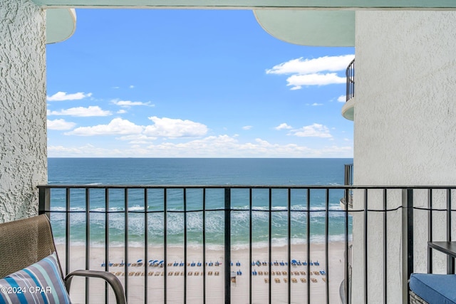 balcony featuring a water view and a beach view