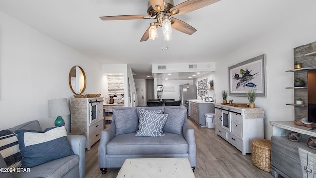 living room with ceiling fan and light hardwood / wood-style floors