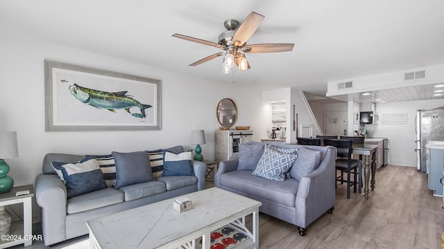 living room with hardwood / wood-style flooring and ceiling fan