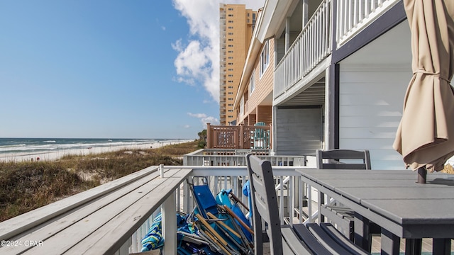 balcony featuring a view of the beach and a water view