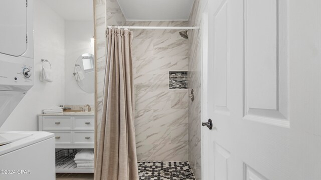 bathroom with a shower with curtain, vanity, and stacked washer and clothes dryer