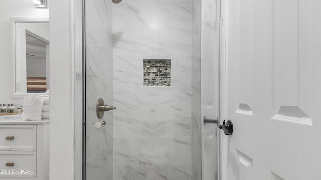 bathroom featuring a tile shower and vanity