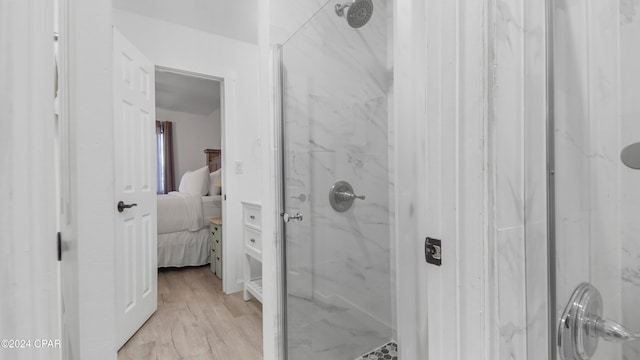 bathroom featuring hardwood / wood-style floors and a tile shower