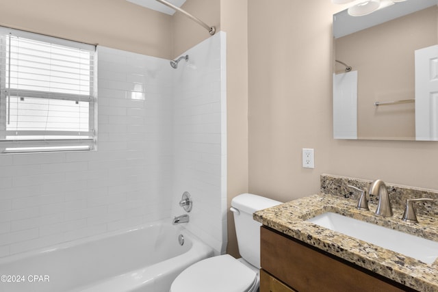 full bathroom featuring tiled shower / bath, vanity, and toilet