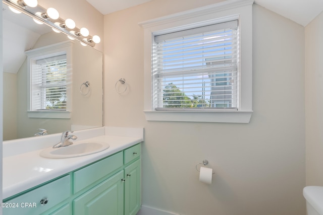 bathroom with vanity, vaulted ceiling, and toilet