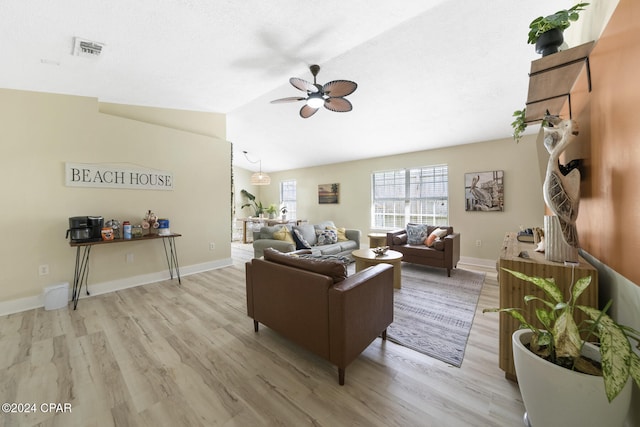 living room featuring ceiling fan, lofted ceiling, and light hardwood / wood-style flooring