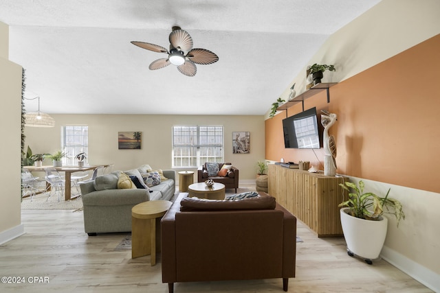 living room with ceiling fan, a textured ceiling, and light hardwood / wood-style floors