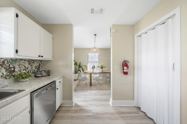 kitchen featuring white cabinetry, stainless steel dishwasher, light hardwood / wood-style floors, and pendant lighting