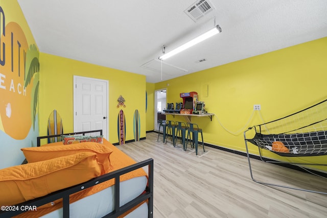 bedroom with light hardwood / wood-style flooring and a textured ceiling