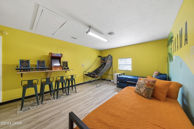 recreation room featuring hardwood / wood-style flooring and a textured ceiling