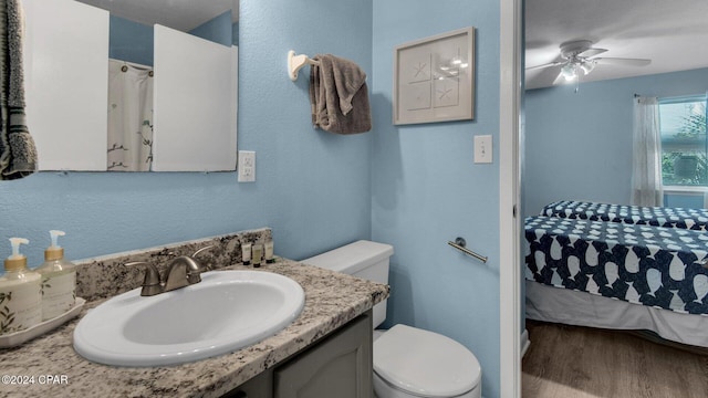 bathroom featuring hardwood / wood-style flooring, ceiling fan, toilet, and vanity