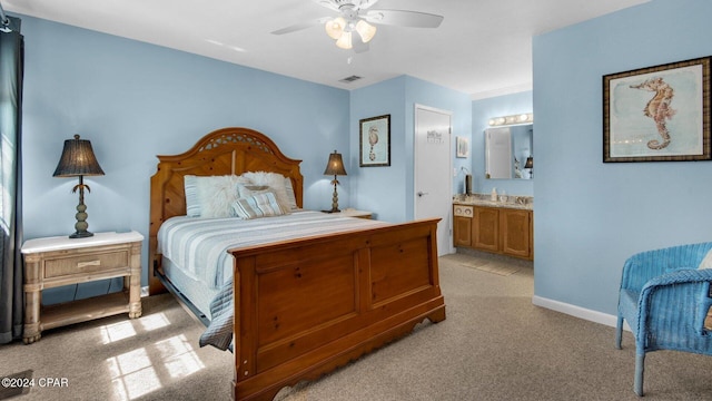 bedroom featuring ensuite bathroom, ceiling fan, and light colored carpet