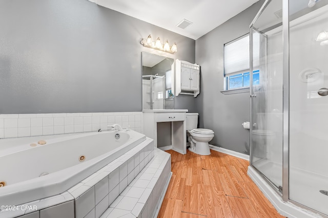 bathroom featuring shower with separate bathtub, hardwood / wood-style flooring, and toilet