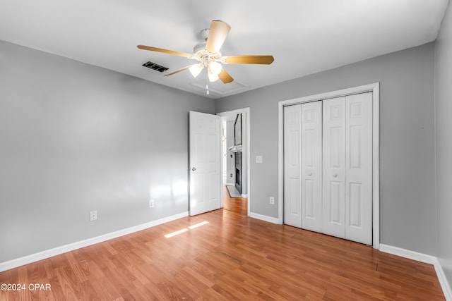 unfurnished bedroom with hardwood / wood-style floors, ceiling fan, and a closet