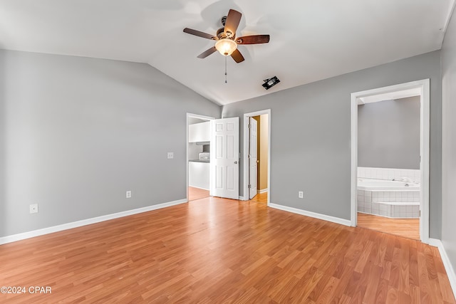 unfurnished bedroom featuring ensuite bathroom, light hardwood / wood-style flooring, ceiling fan, and lofted ceiling