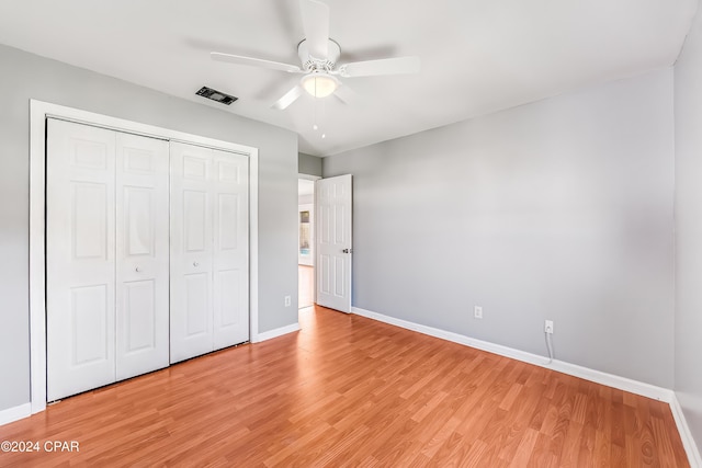 unfurnished bedroom featuring a closet, light hardwood / wood-style flooring, and ceiling fan