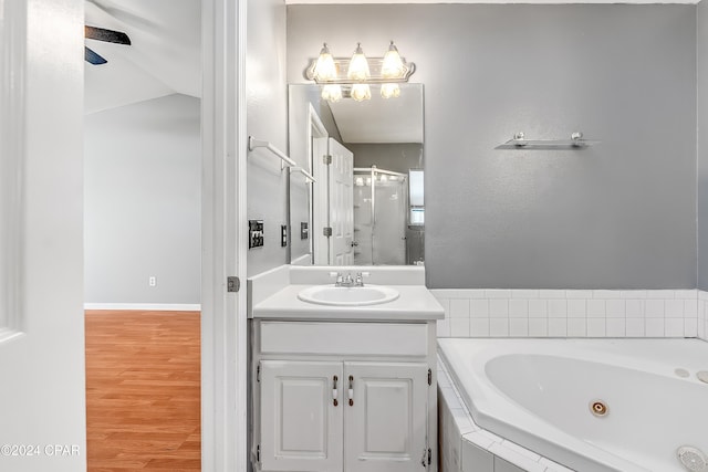 bathroom featuring hardwood / wood-style floors, vanity, lofted ceiling, and shower with separate bathtub