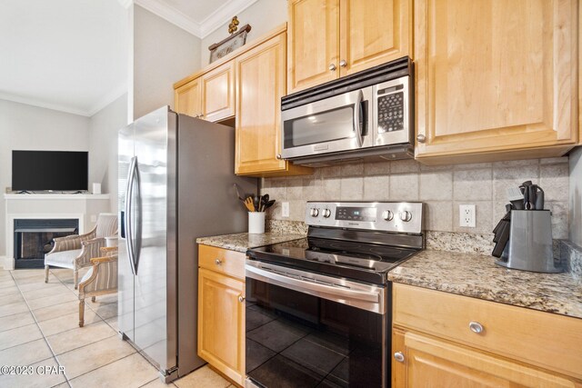 kitchen with light stone countertops, decorative backsplash, ornamental molding, stainless steel appliances, and light tile patterned floors