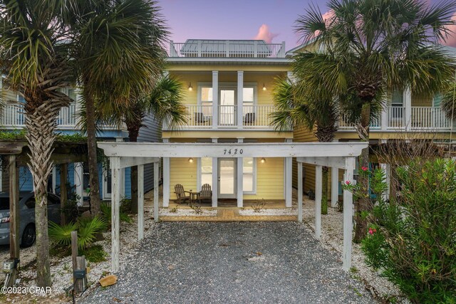 back house at dusk featuring a balcony