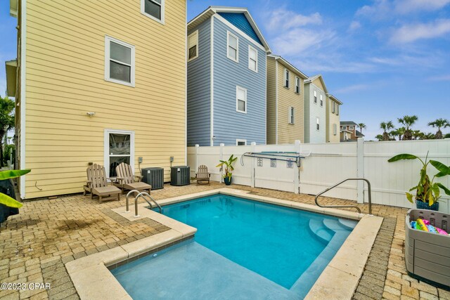 exterior space featuring a fenced in pool, a patio area, and central AC