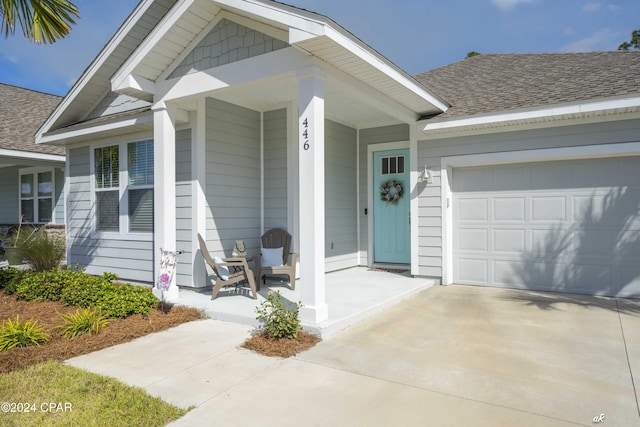 entrance to property with covered porch and a garage