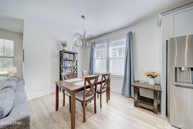 dining space featuring light hardwood / wood-style flooring and an inviting chandelier