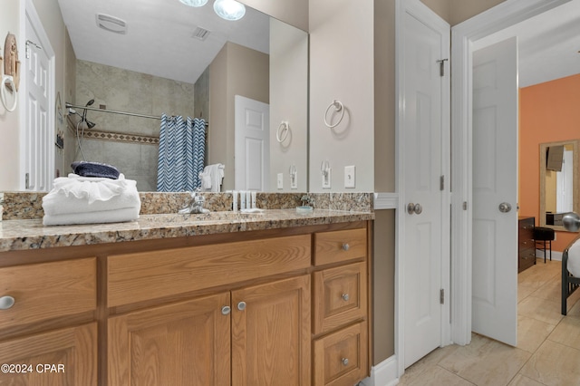 bathroom featuring curtained shower, tile patterned flooring, and vanity