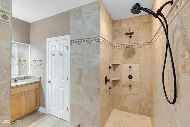 bathroom with a tile shower and vanity