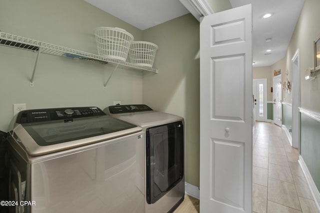 clothes washing area with separate washer and dryer and light tile patterned floors