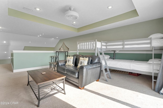 carpeted bedroom featuring a raised ceiling