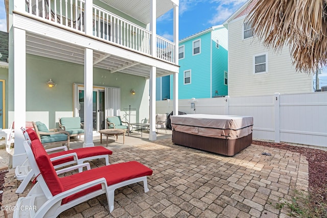 view of patio featuring a hot tub and a balcony