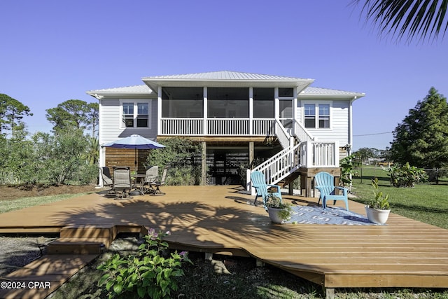 back of house with a sunroom, a yard, and a wooden deck