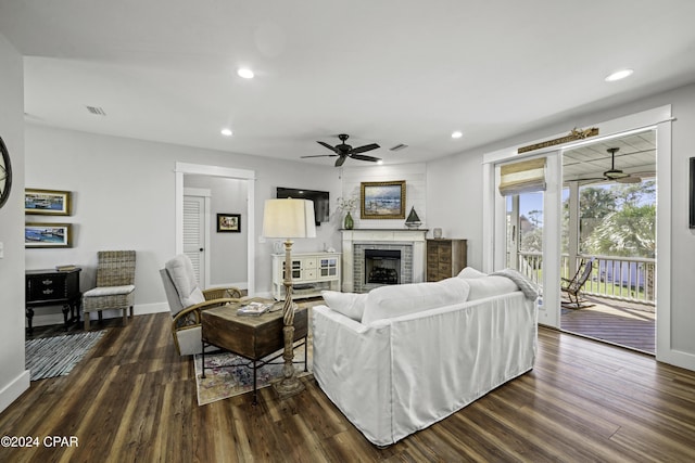 living room with ceiling fan, a fireplace, and dark hardwood / wood-style floors