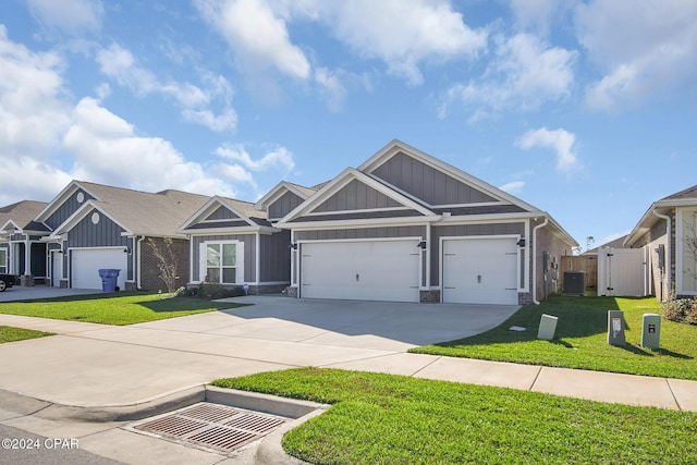 view of front of home featuring a garage, central AC unit, and a front lawn