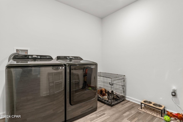 laundry room featuring separate washer and dryer and light wood-type flooring