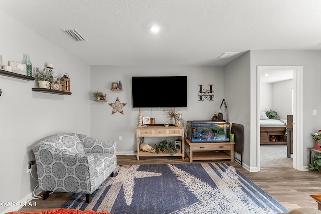 sitting room with wood-type flooring and a textured ceiling