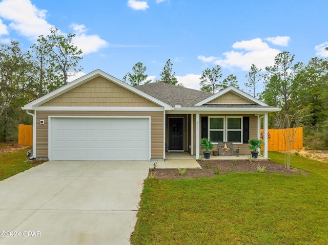 view of front of property featuring a garage, a porch, and a front yard