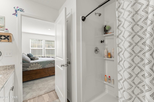 bathroom with curtained shower, hardwood / wood-style floors, and vanity