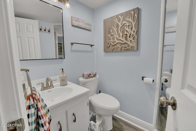 bathroom featuring hardwood / wood-style floors, vanity, and toilet