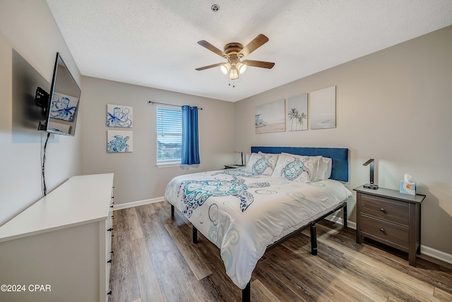 bedroom featuring ceiling fan, light hardwood / wood-style floors, and a textured ceiling