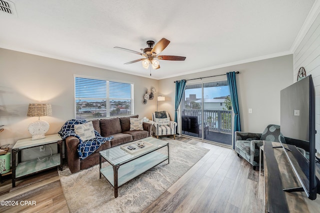 living room featuring hardwood / wood-style flooring, plenty of natural light, and crown molding