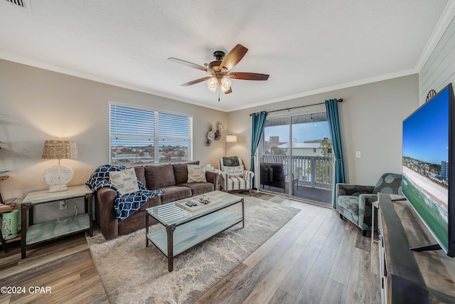 living room featuring hardwood / wood-style flooring, plenty of natural light, crown molding, and ceiling fan