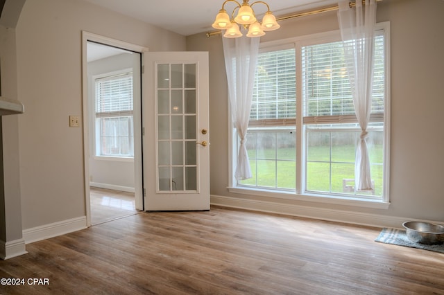 unfurnished dining area with a chandelier and hardwood / wood-style floors