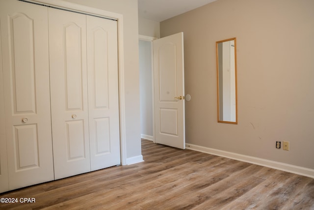 unfurnished bedroom featuring light wood-type flooring and a closet