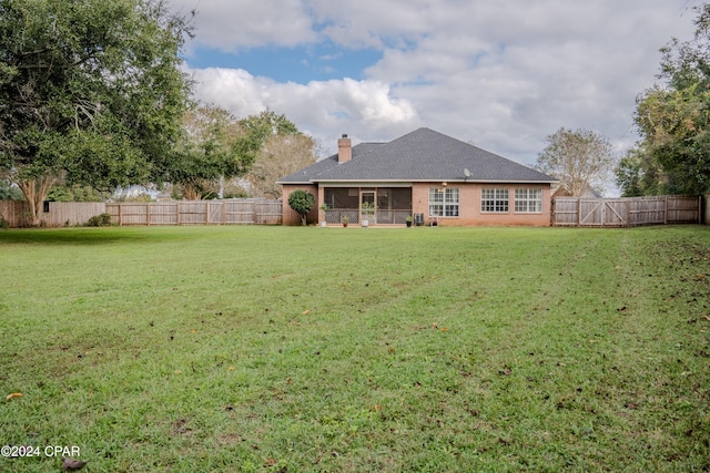 rear view of house with a yard